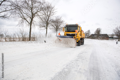 Räumfahrzeug auf schneebedeckter Straße im Winterdienst