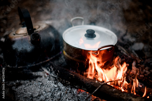 iron kettle and saucepan stands on the coals of fire