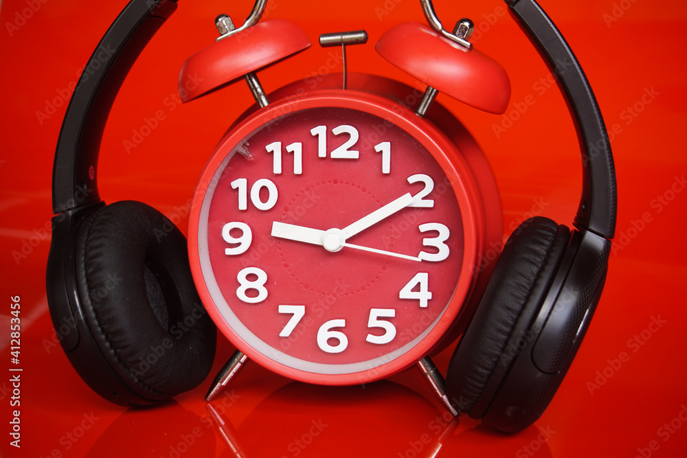 Retro alarm clock and headphone with retro red background Retro alarm clock and headphone with retro red background