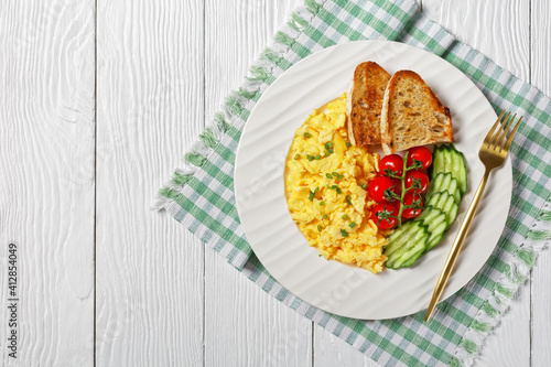 scrambled eggs with veggies and bread on a plate