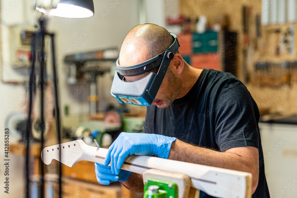 luthier at work with precision lenses, craftsman expert in musical