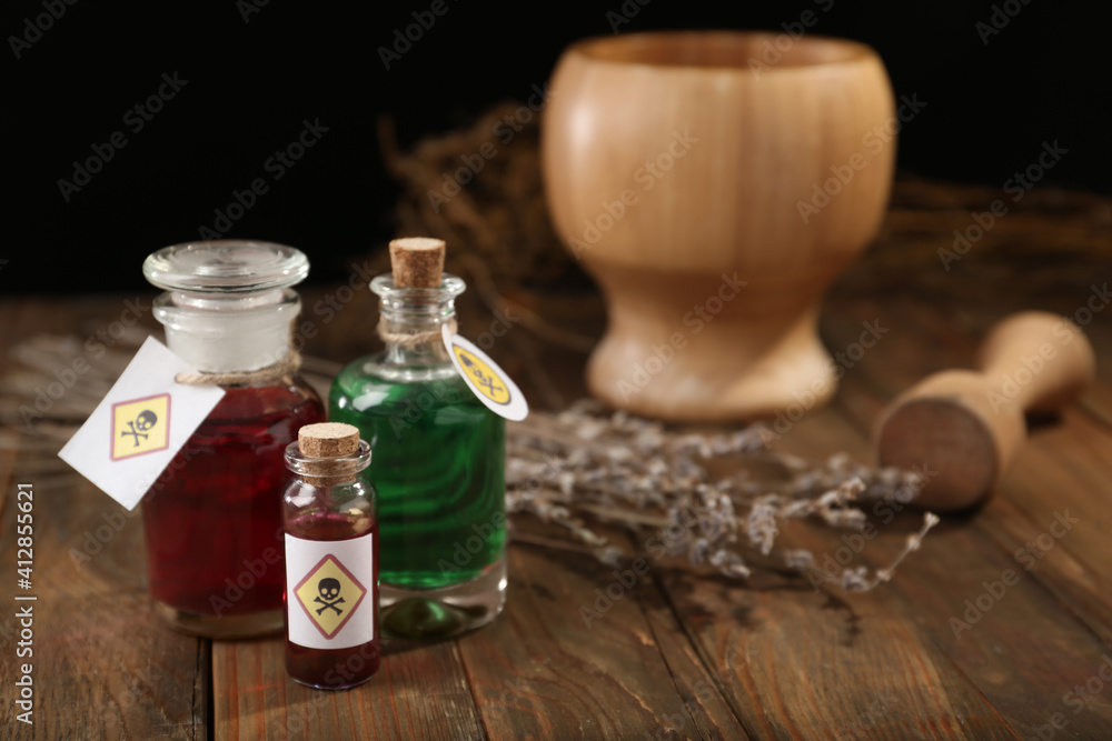Bottles with poisons on wooden table. Space for text Bottles with poisons on wooden table. Space for text