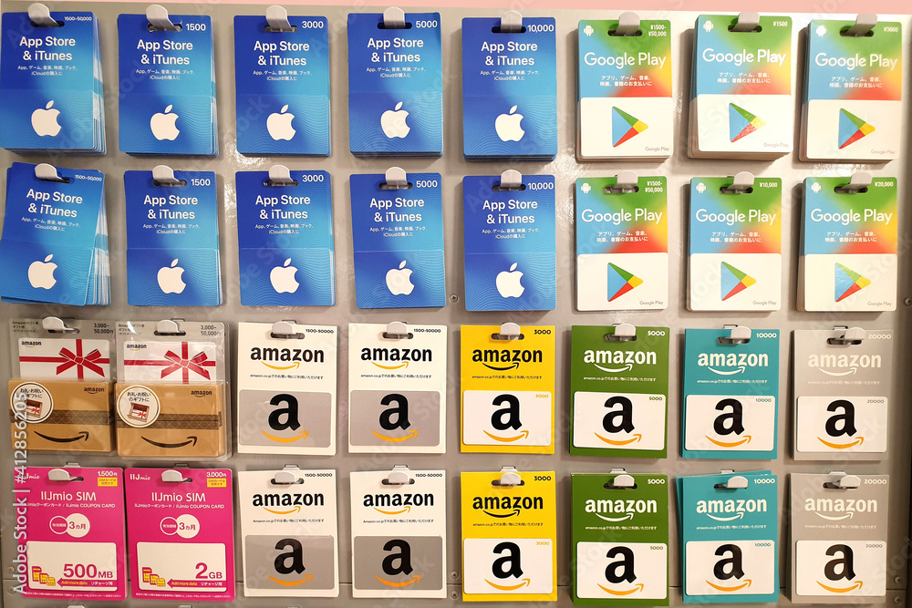 Apple App Store, Amazon and Google play gift cards on store shelf. A gift  card is