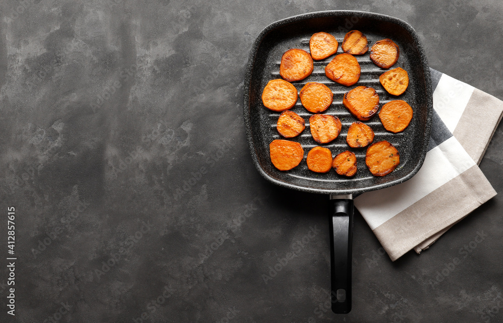 Delicious grilled sweet potatoes in a frying pan on a texture table Delicious grilled sweet potatoes in a frying pan on a texture table