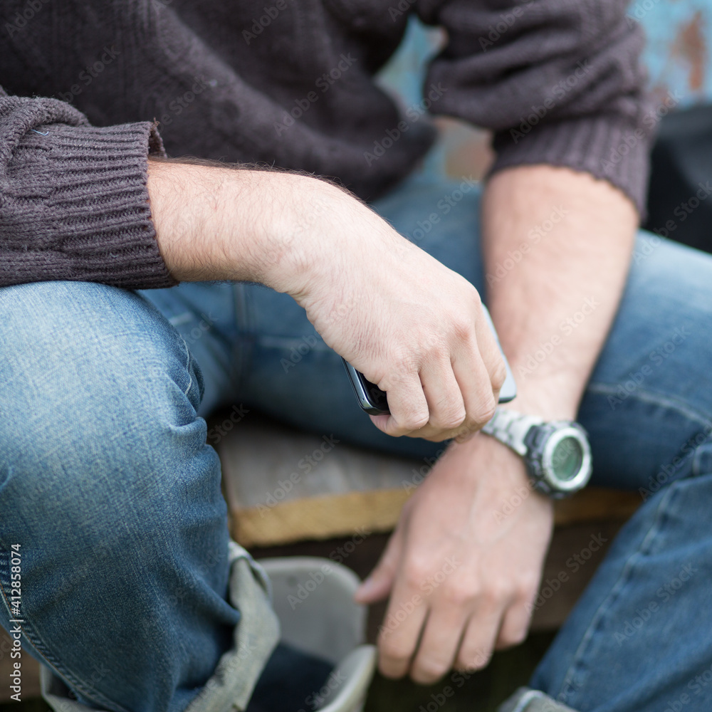 hands of person with a watch and holding  a smartphone