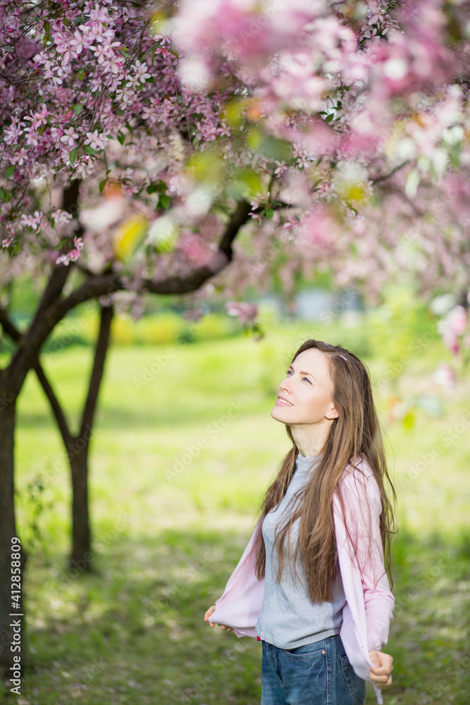 Young woman in blooming park among colorful plants Young woman in blooming park among colorful plants