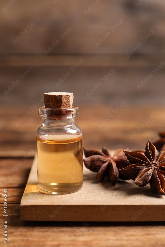 Bottle of essential oil and anise on wooden table Bottle of essential oil and anise on wooden table