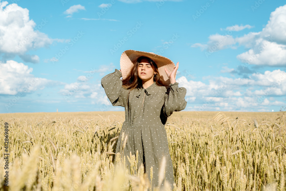 young woman in white dress, straw hat , flower field,ears of bread. young woman in white dress, straw hat , flower field,ears of bread.
