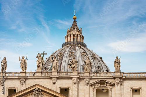 Closeup of the famous Basilica of Saint Peter with de dome, the marble statues of Jesus Christ, of St. John the Baptist and te apostles. Vatican city. Rome, Lazio, Europe.