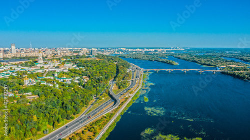 Aerial view to the Beautiful cityscape city Kiev with a Dnepr river in sunny day. Top view to the urban landscape. Panorama of a big european city.