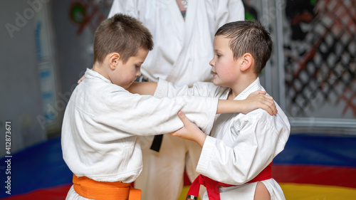 Two boys practice martial arts in a gym
