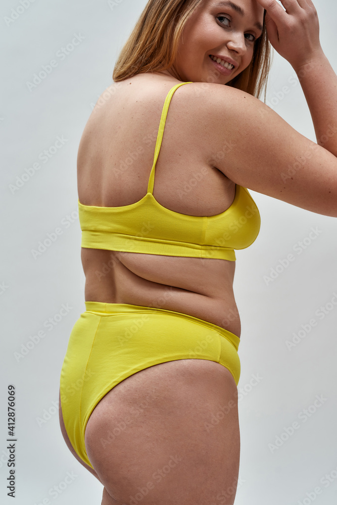 Back View Of Cute Curvy Babe Woman Wearing Yellow Underwear Turning Head To Camera And Smiling