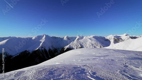 A stunning view of snow-covered hills and mountains on a sunny day, trackin photo