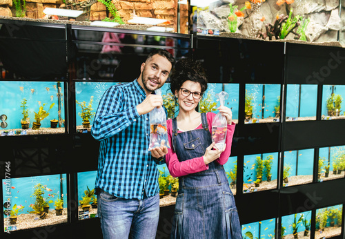 Photography Happy couple buying pet fishes in pet shop.