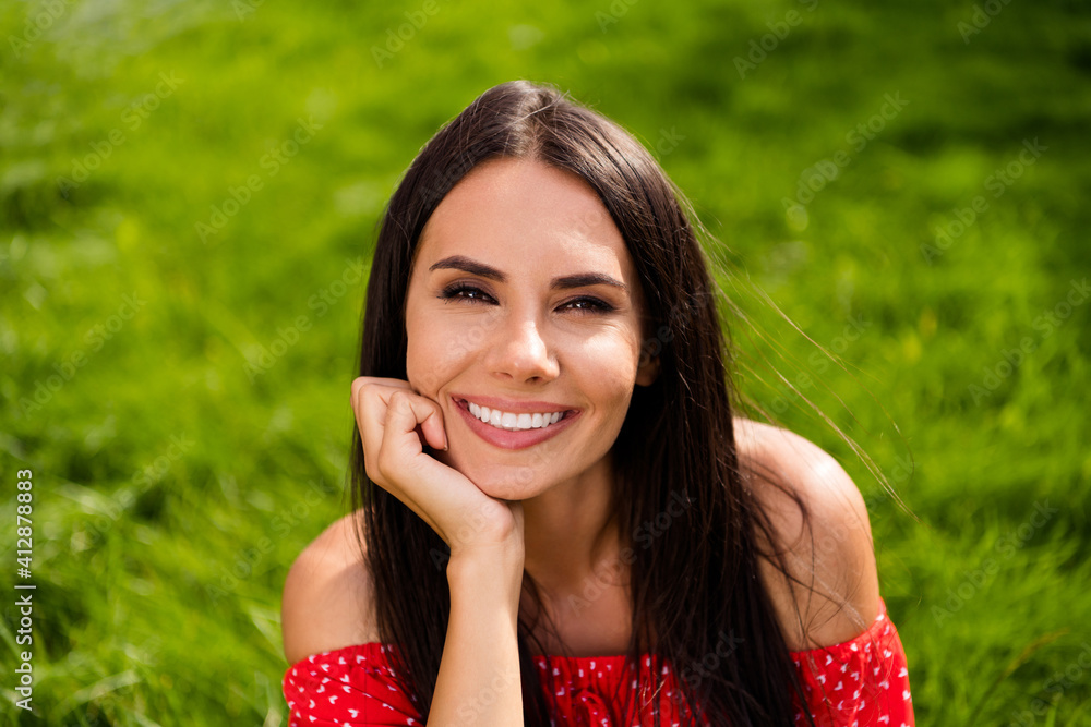 Photo of cute pretty young woman dressed red off-shoulders dress arm chin sitting grass outdoors backyard