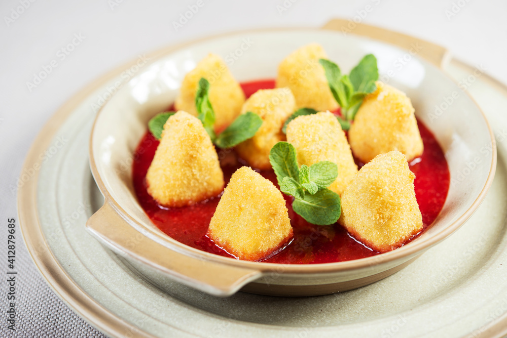 portion of fresh made fried camembert cheese served with berry jam portion of fresh made fried camembert cheese served with berry jam