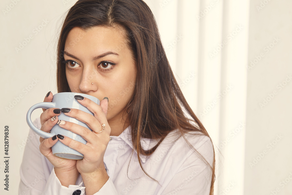 Candid image of a businesswoman drinking coffee while working at office. Selective focus. Candid image of a businesswoman drinking coffee while working at office. Selective focus.