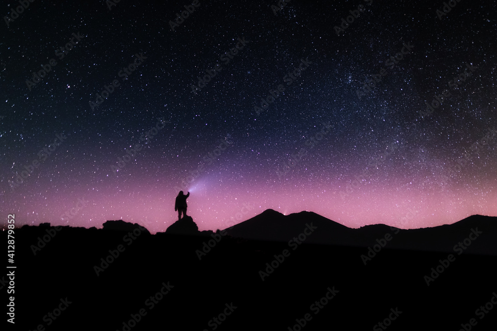 Fototapeta Silueta de una persona en la noche bajo las estrellas