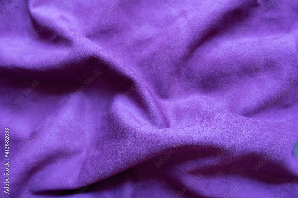 Violet faux suede fabric in soft folds Violet faux suede fabric in soft folds