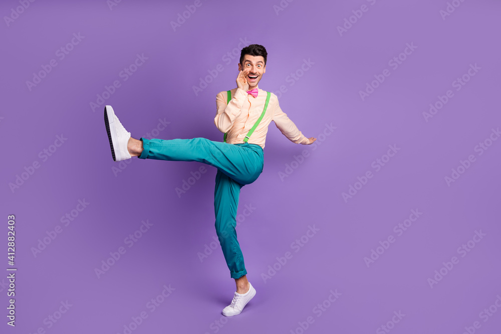 Fototapeta premium Photo of cheerful funky young guy wear yellow shirt dancing making announcement arm lips isolated violet color background