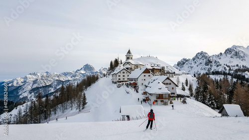 Idyllic village on top of hill in winter. Ski resort, skiing, tourism. Monte Lussari, Italy. photo