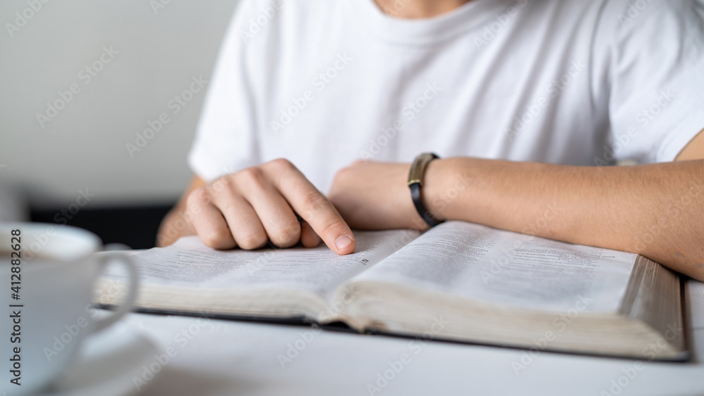 A boy reading a book on the table