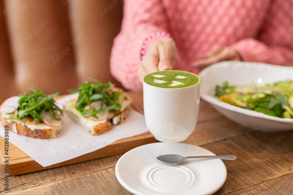 Healthy breakfast in the restaurant. Green salad, bruschetta with arugula and salmon and matcha latte Healthy breakfast in the restaurant. Green salad, bruschetta with arugula and salmon and matcha latte