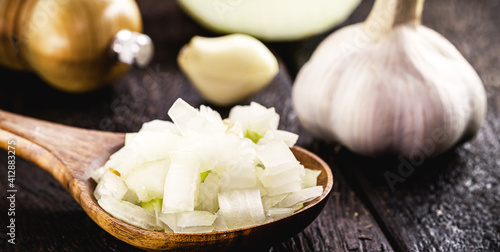 Wallpaper Mural wooden spoon with chopped organic onion, with garlic clove in the background. Vintage rustic kitchen Torontodigital.ca