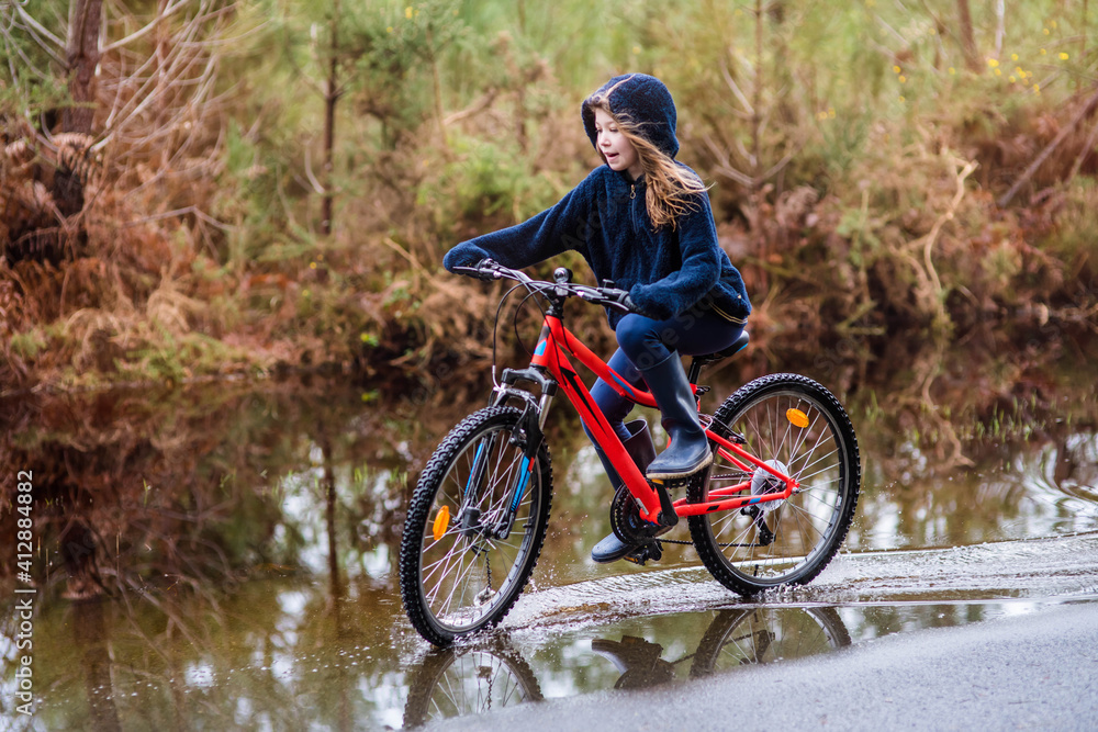 Obraz premium beautiful young girl playing while rolling in puddles