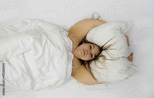 Obraz na plátně Portrait of a confident positive cheerful plump woman in bed hugging pillow
