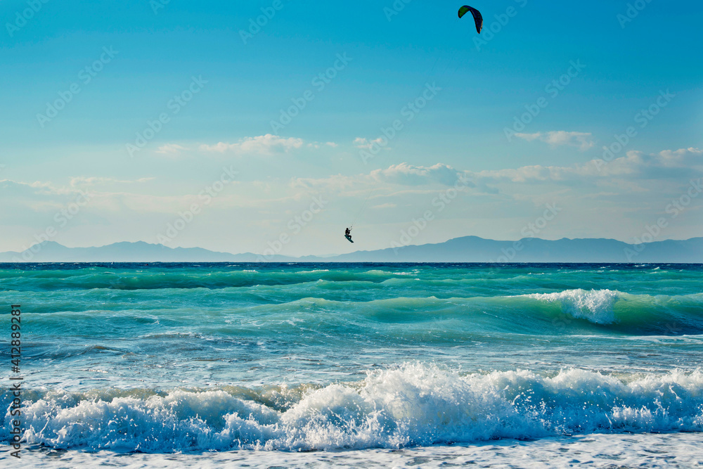 Windsurfers on the sea shore Greece, Rhodes island . Surfers in the background of mountains in the distance. Summer sunny day.