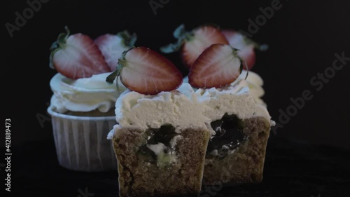 Delicious cupcake with filling inside. Fresh strawberries.