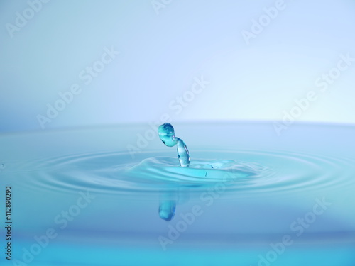 Gouttes d'eau présentant des motifs abstraits lors de la collision. Fond blanc et bleu.