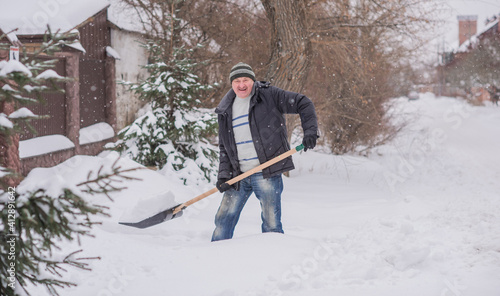 Snow collapse, man cleaning snow at winter weather with a shovel on a yard, winter trouble concept