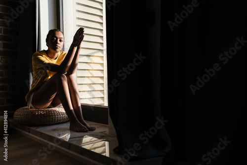 Serious african american girl listening music with earphones