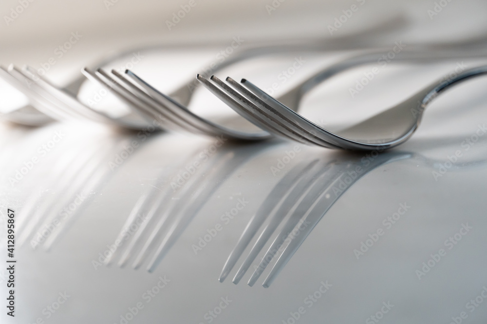 Row of Forks on white marble texture background. Concept for food and dining tableware Row of Forks on white marble texture background. Concept for food and dining tableware