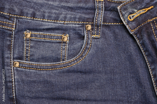 Thread-stitched front pocket of blue fashion jeans with studs. © ss404045