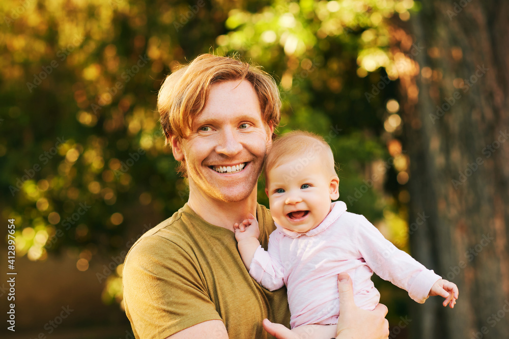 Outdoor portrait of happy young father with adorable baby Outdoor portrait of happy young father with adorable baby