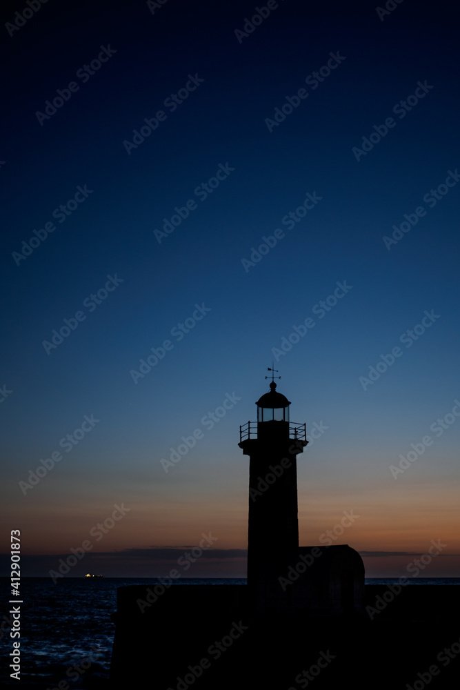 Lighthouse in sunset in front of sea