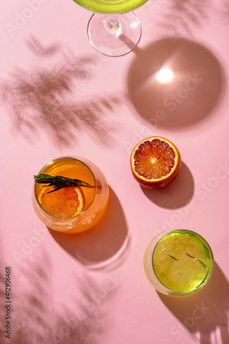 Popular summer ice alcoholic cocktails served under the summer sun light, view from above.