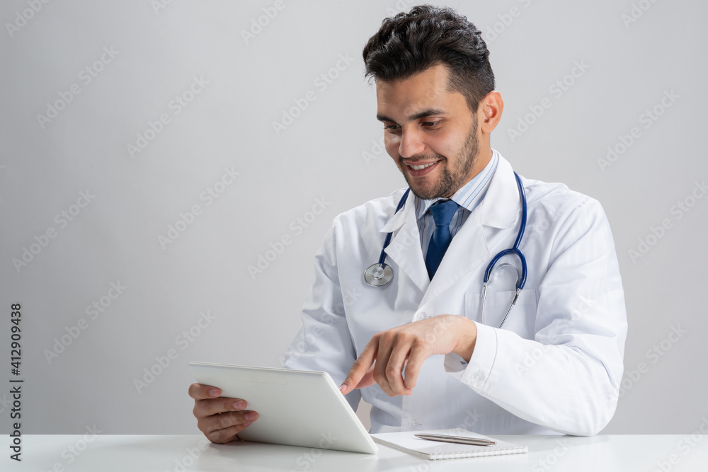 Young smiling internist using tablet computer Young smiling internist using tablet computer