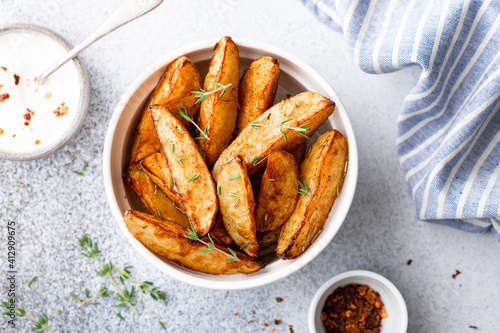 Photo baked potato wedges with sauce on a light background, top view