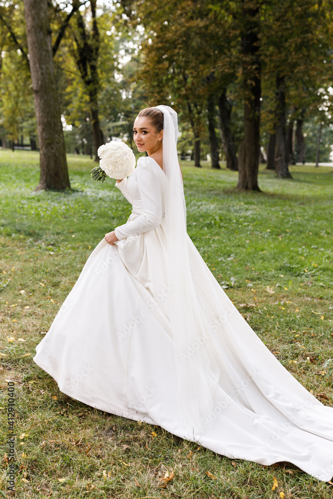 Portrait of a beautiful blonde bride with flowers in park. Wedding day Portrait of a beautiful blonde bride with flowers in park. Wedding day