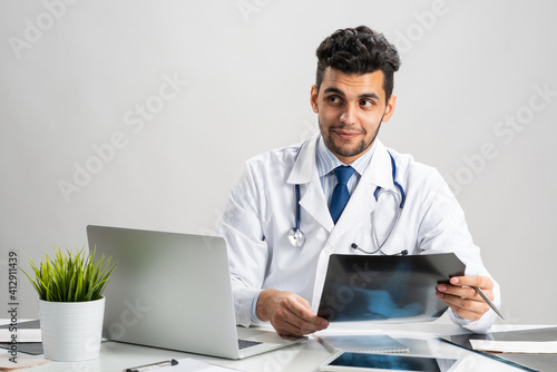 Handsome young doctor looking at x-ray scan