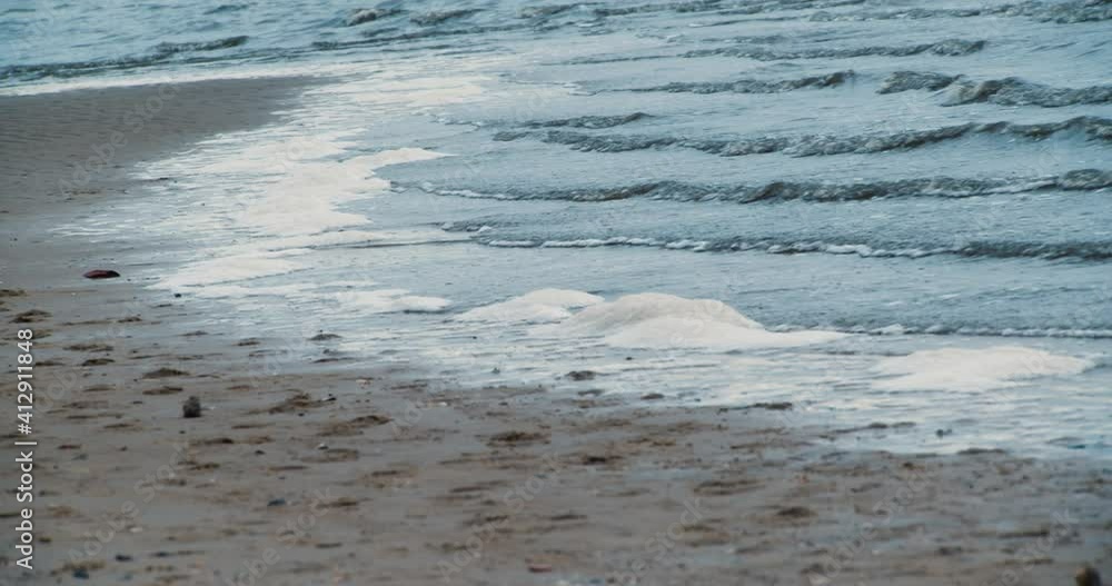 Petite vague sur plage temps gris nuageux Petite vague sur plage temps gris nuageux