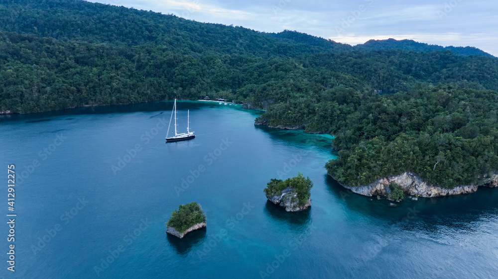 Aerial View Of Triton Bay, Raja Ampat Islands: Boat In Lagoon With Turquoise Water And Green Tropical Trees. Wide Angle Nature: Pacific Ocean And Stunning Landscape In Papua, Indonesia.