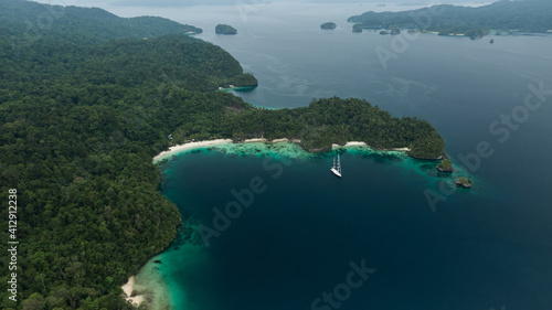 Triton Bay In Raja Ampat Islands: Boat On Turquoise Sea And Green Tropical Trees. Aerial View Of Wide Angle Nature; Pacific Ocean And Picturesque Landscape In Papua, Indonesia.