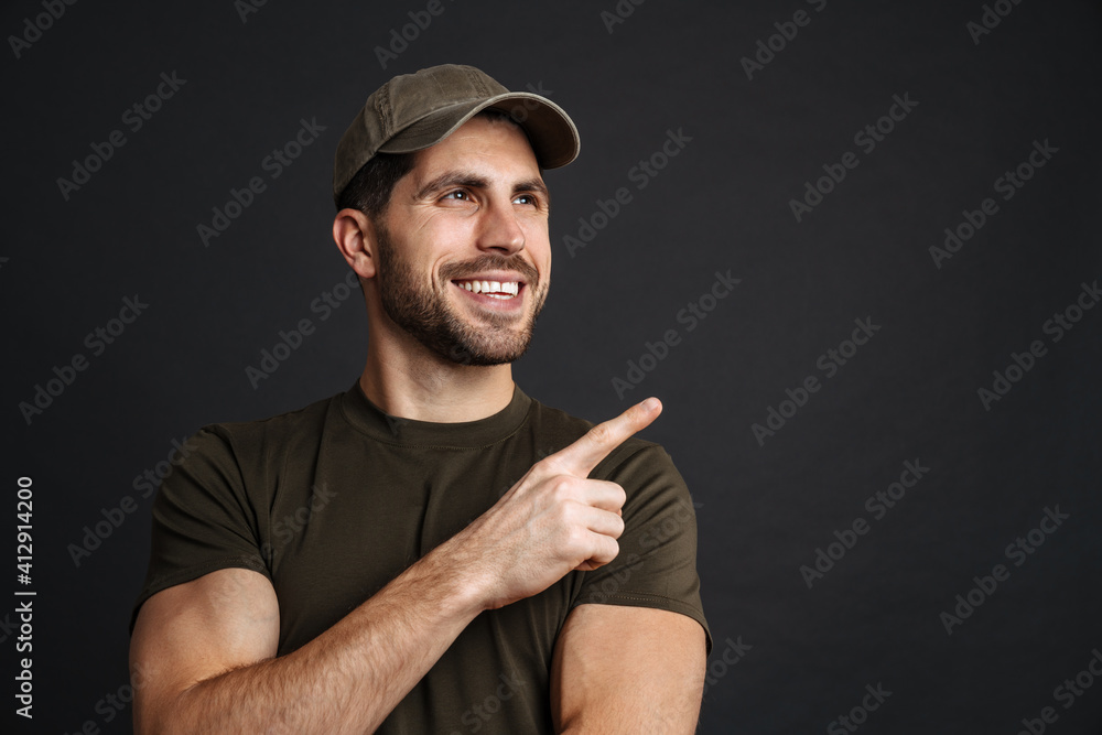 Smiling young man soldier presenting copy space Smiling young man soldier presenting copy space