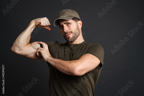 Strong healthy military man showing biceps isolated
