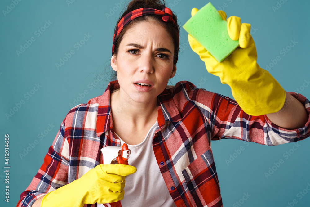 Perplexed caucasian young woman in gloves cleaning glass Perplexed caucasian young woman in gloves cleaning glass
